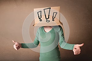 Young lady gesturing with a cardboard box on her head with exclamation point