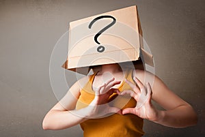 Young lady gesturing with a cardboard box on her head with quest