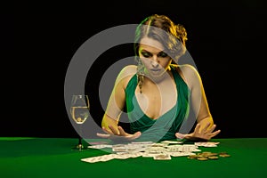 A young lady in a green dress is playing solitaire made from scrying cards