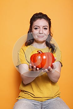 Young lady gripping a bell pepper