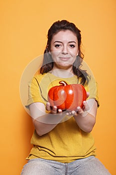 Young lady gripping a bell pepper photo