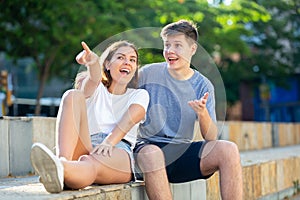 Young lady and her boyfriend are sitting on the step