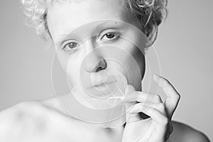 Young lady holding in her hands a dry leaf and looked in the camera.