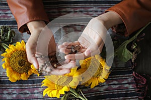 Young lady holding rosary in hand. Female hands praying holding a rosary with Jesus Christ Cross or Crucifix. Junior woman with