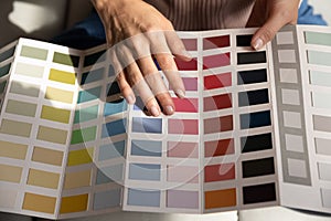 Young lady illustrator hold palette of colored samples in hands