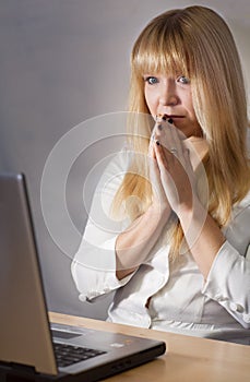 Young lady looking worried in front of her computer