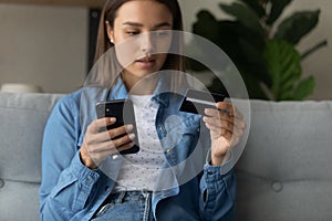 Young lady making purchase at internet shop using cell