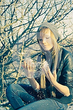 Young lady near tree snow flaking