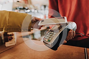 Young lady pay bill via contactless payments