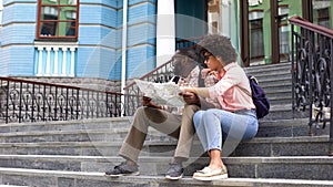 Young lady pointing at map searching direction with boyfriend, couple travelling