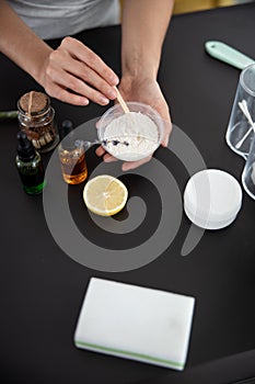 Young lady preparing cosmetic clay for mask