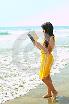 Young lady reading a book on the beach