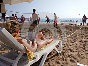 The young lady is reading book on the beach