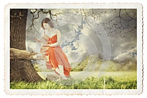 Young lady reading a book under a tree