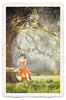 Young lady reading a book under a tree