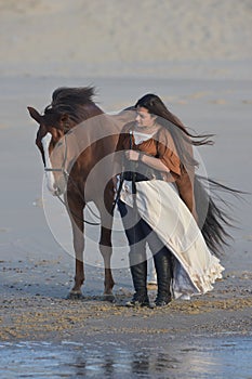 Young lady riding a horse at beach in early morning