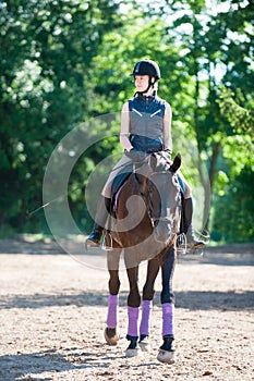 Young lady riding a horse at equestrian school. Training process