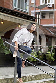 Young lady.She screams in pain.Probably hurt her high-heeled foot.