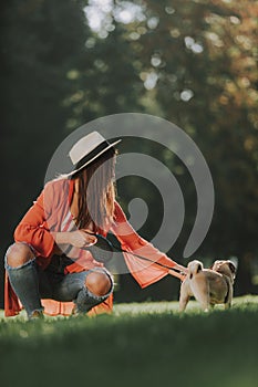 Young lady is sitting on grass with her dog