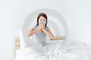 Young lady sneeze on the bed and need more rest