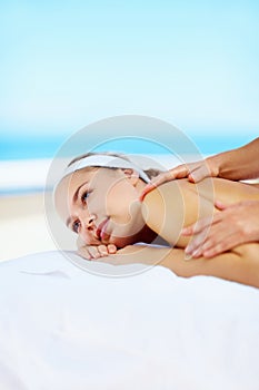 Young lady in a spa receiving a massage therapy outside. Beautiful woman in a spa receiving a massage therapy outside.