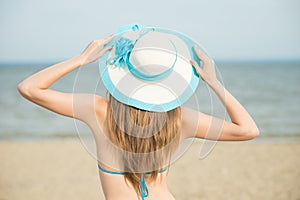 Young lady sunbathing on a beach. Beautiful woman posing at the