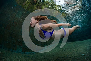 Young lady swimming underwater