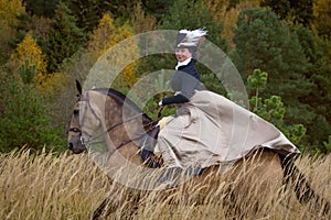 Young lady in 19th century dress riding a akhal teke horse