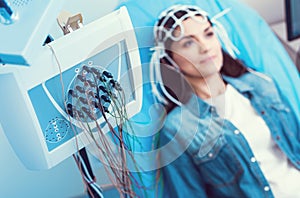 Young lady undergoing electroencephalography analysis at laboratory photo