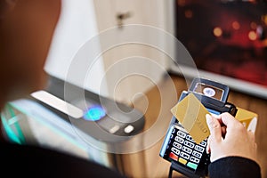 Young lady using gold card for contactless payment