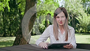 Young lady using an ipad in the park