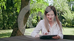 Young Lady Using an iPad in the Park