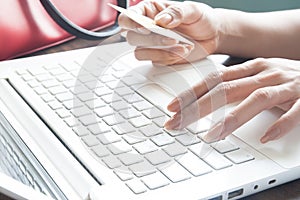 Young lady using laptop and holding credit card, Online shopping