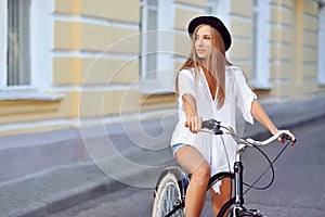 Young lady on a vintage bicycle looking at copyspace