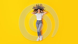 Young Lady Wearing Headphones Relaxing Listening Music Over Yellow Background