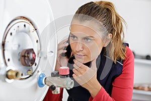 Young lady working on boiler making phonecall