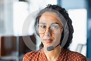 A young Latin American woman in a headset. Call center, service operator, hotline, support line