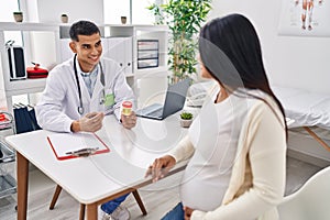 Young latin couple doctor and patient having medical session holding urine test tube at clinic