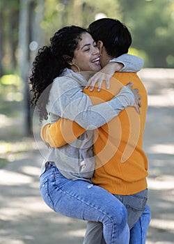 Young latin couple smiling confident hugging each other at park