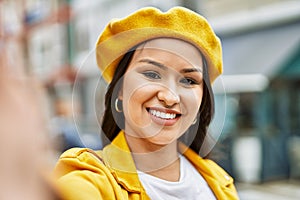 Young latin girl smiling happy making selfie by the camera at the city