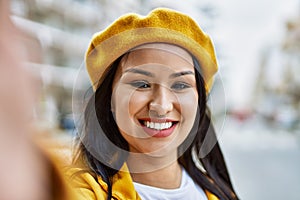 Young latin girl smiling happy making selfie by the camera at the city