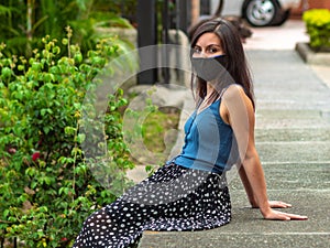 Young Latin / Hispanic Woman with a Dark Handcraft Face Mask