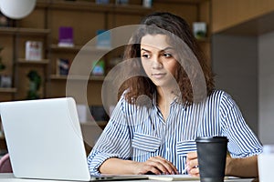 Young latin indian student using laptop watching online virtual training.