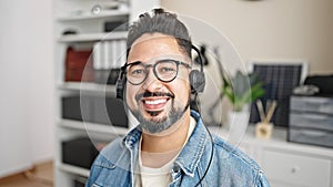 Young latin man business worker using laptop and headphones working at office