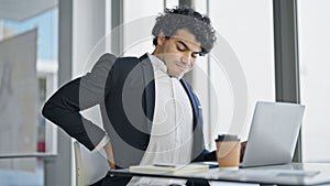 Young latin man business worker using laptop suffering for backache at office