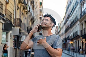 Young latin man in the city talking by mobile phone.