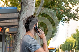 Young latin man in the city talking by mobile phone.