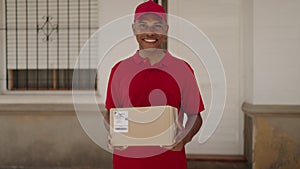 Young latin man delivery worker holding package at street