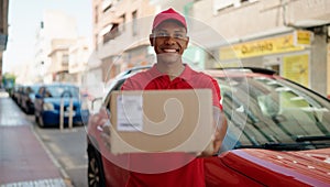 Young latin man delivery worker holding package at street