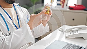 Young latin man doctor prescribing pills at clinic